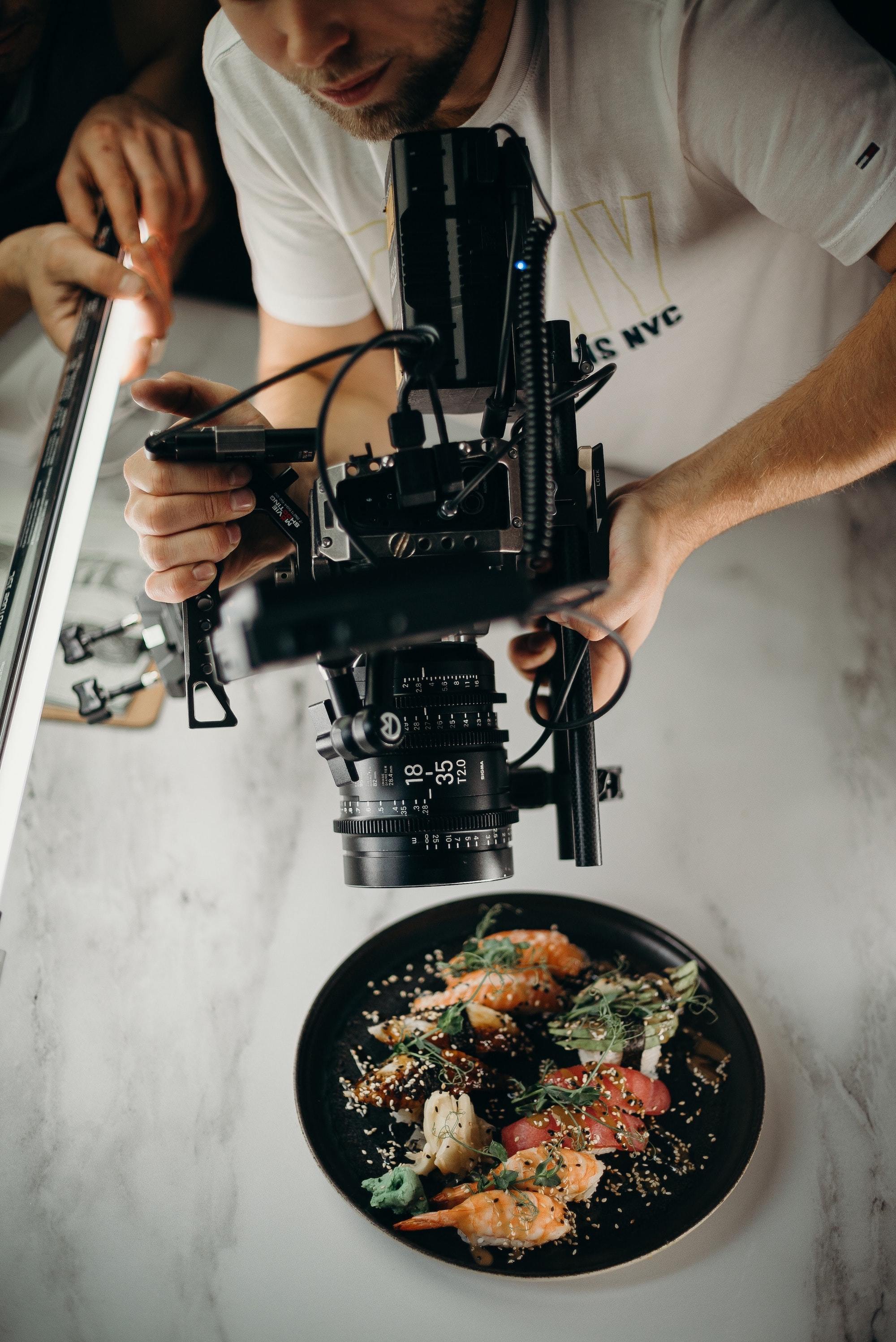 Man using video camera pointing on food on plate 3298603