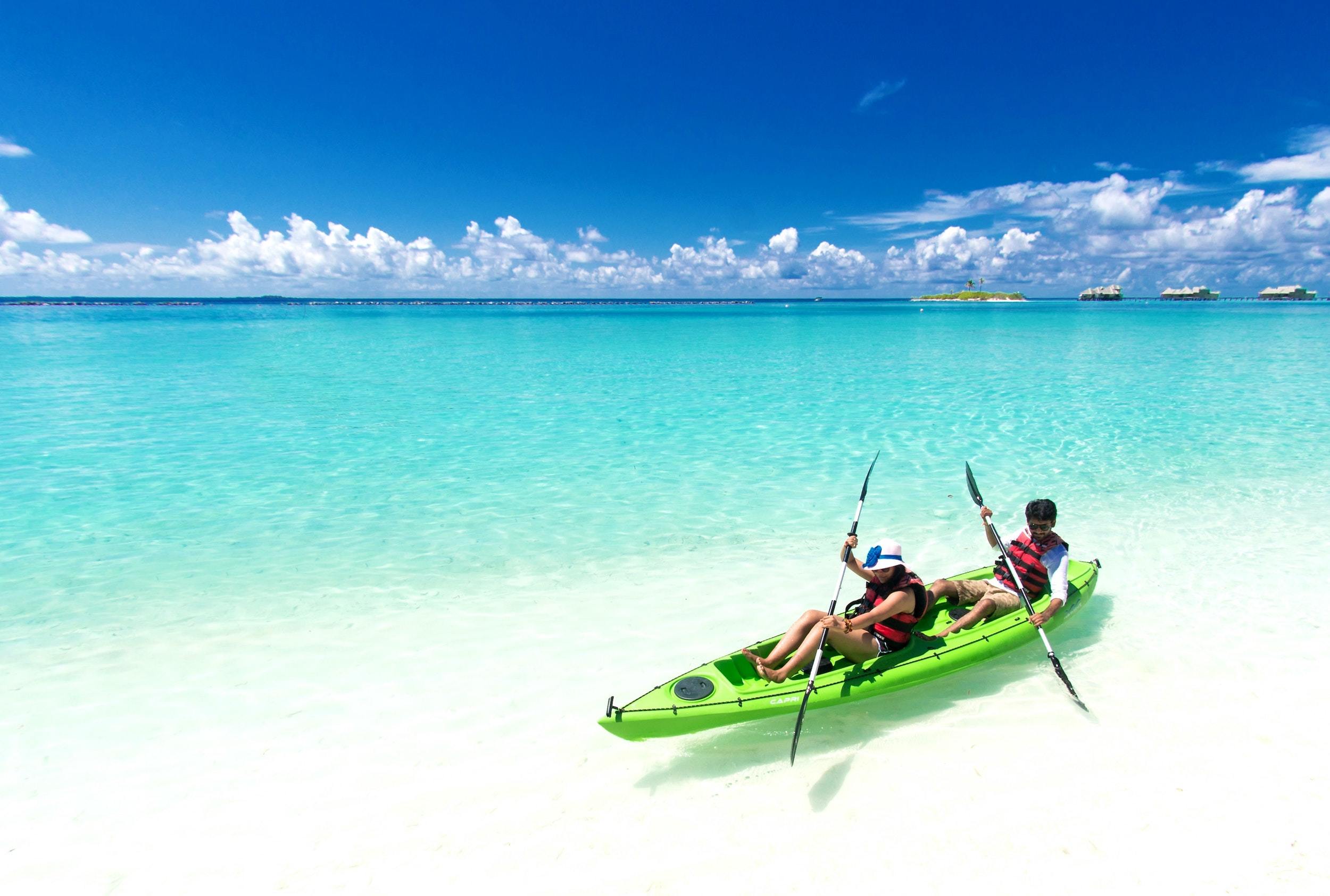 Two people riding green kayak on sea 1430672